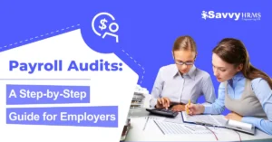 Two professionals reviewing payroll audits documents at a desk with calculators and papers, branded with Savvy HRMS for payroll audit compliance.​